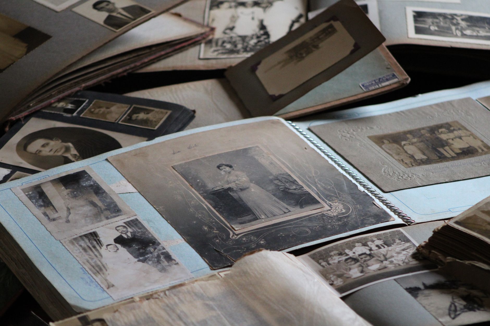 Open family photo albums spread across a table, filled with old black and white portraits